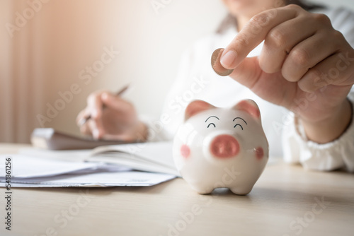 Money save concept woman put coin in piggy bank. Coin currency deposit for household expense.
