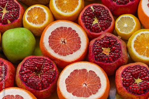 Ripe oranges, lemons, grapefruit, pomegranates, and apples notched to squeeze juice on the counter, Turkey photo