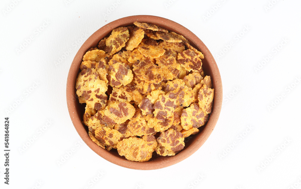 A popular Indian street snack called Chana jor garam made from flattened chickpeas that are roasted and spiced placed in a terracotta bowl placed on a white background A popular Indian street snack called Chana jor garam made from flattened chickpeas that are roasted and spiced placed in a terracotta bowl placed on a white background