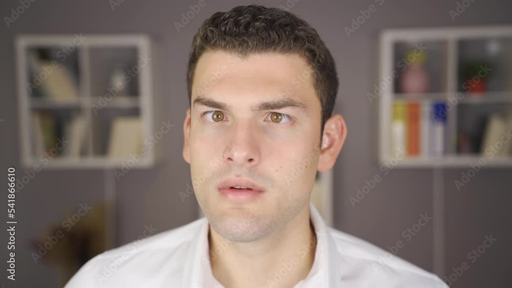 The cross-eyed man looks around strangely. Young squint man trying to