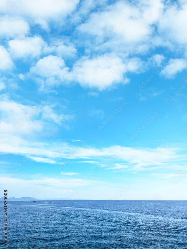 真っ青な空に浮かぶ白い雲と海の地平線