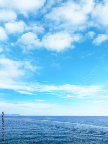 Fotobehang 真っ青な空に浮かぶ白い雲と海の地平線