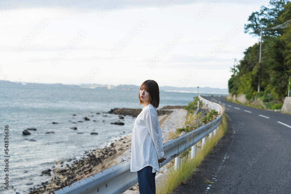 夕暮れの海岸線にいる女性