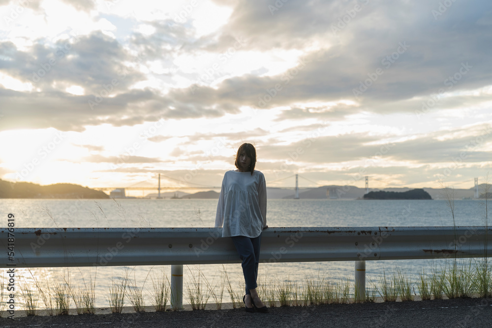 夕暮れの海にいる女性