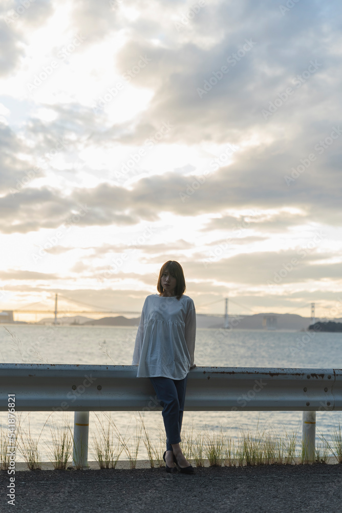 夕暮れの海にいる女性