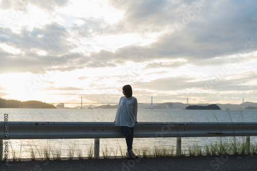 夕暮れの海にいる女性