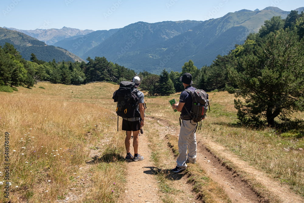 Deux randonneurs observant les montagnes Pyrénéennes lors d'une balade estivale