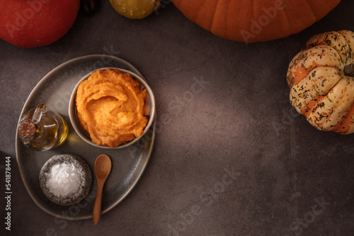 Homemade pumpkin purée for cooking in dark moody background with copy space