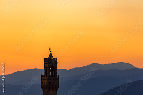 Palazzo vecchio tower in Florence with the mountains at sunset