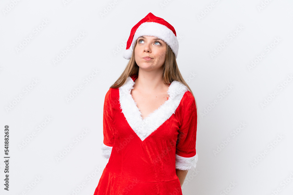 Young caucasian woman dressed as mama noel isolated on white background and looking up Young caucasian woman dressed as mama noel isolated on white background and looking up