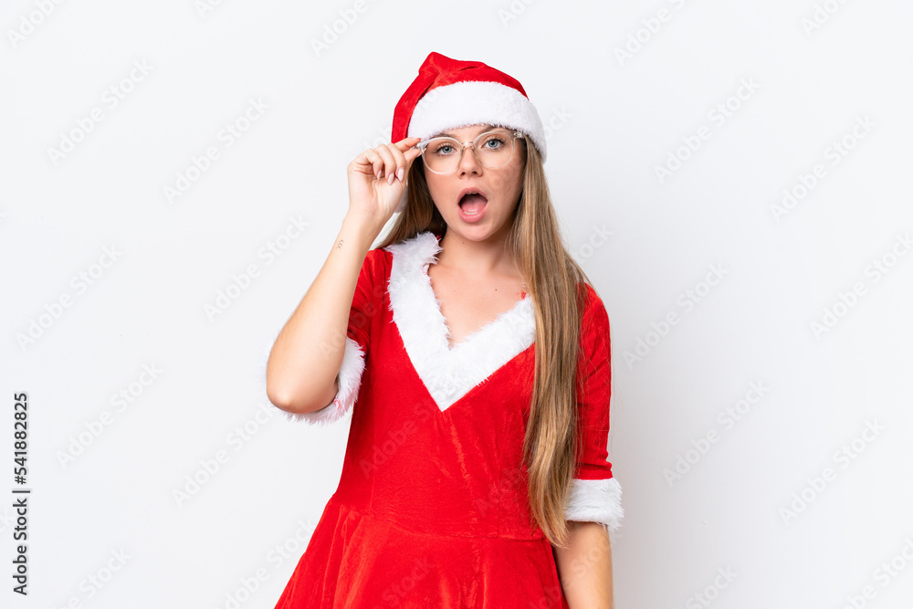 Young caucasian woman dressed as mama noel isolated on white background with glasses and surprised Young caucasian woman dressed as mama noel isolated on white background with glasses and surprised