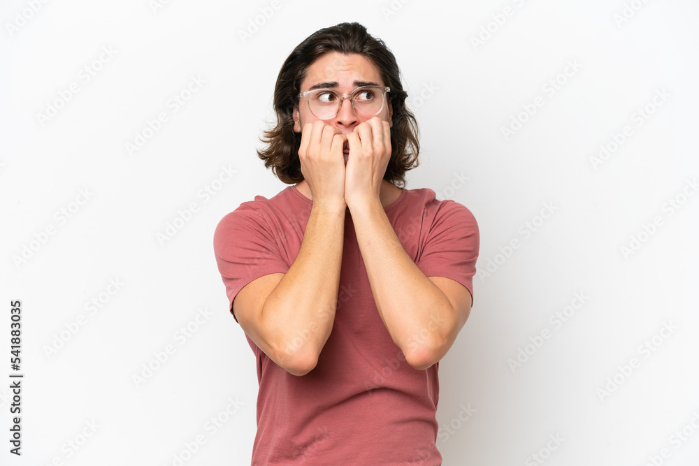 Young handsome man isolated on white background nervous and scared putting hands to mouth Young handsome man isolated on white background nervous and scared putting hands to mouth