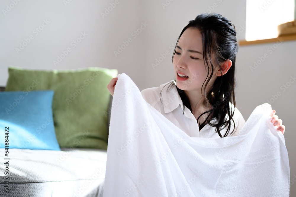 洗濯のタオルを臭くてびっくりする女性 洗濯のタオルを臭くてびっくりする女性