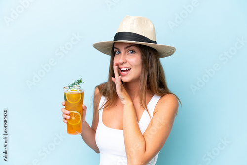 Young beautiful woman holding a cocktail isolated on blue background whispering something