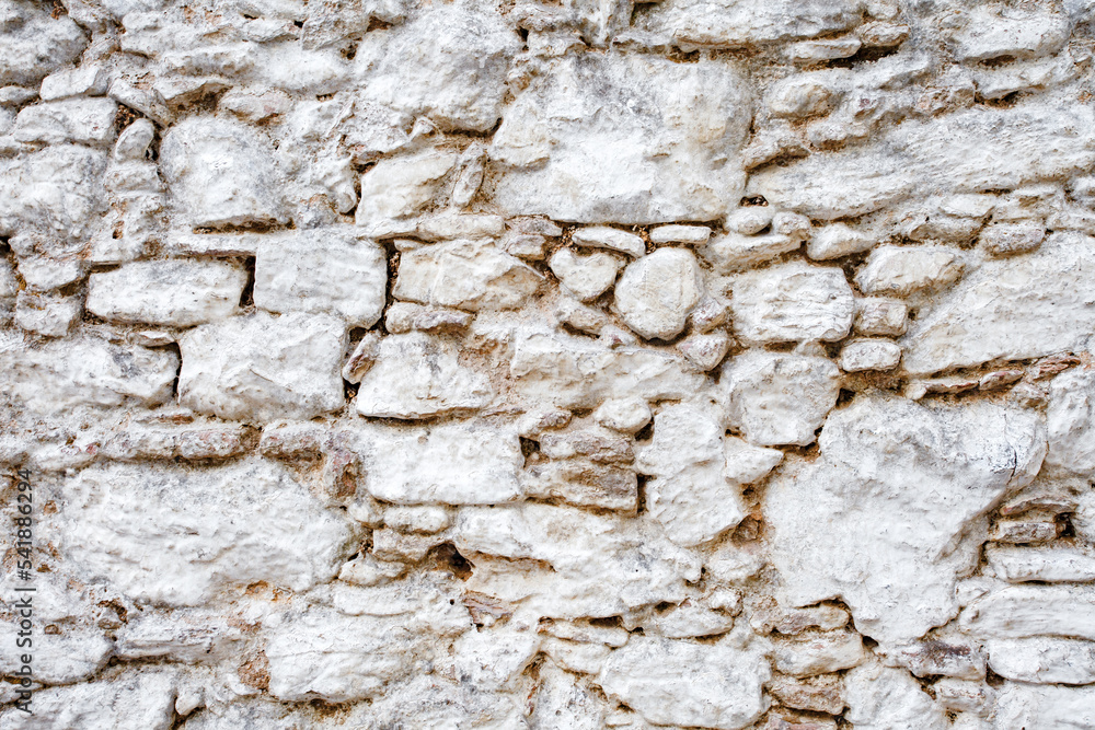 Wall old made of big crooked broken stones, rough blocks  background.