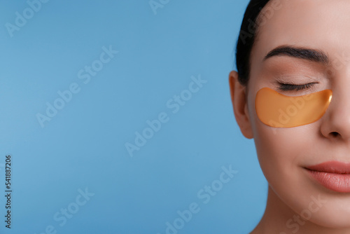 Obraz na plátně Beautiful young woman with under eye patch on light blue background, closeup
