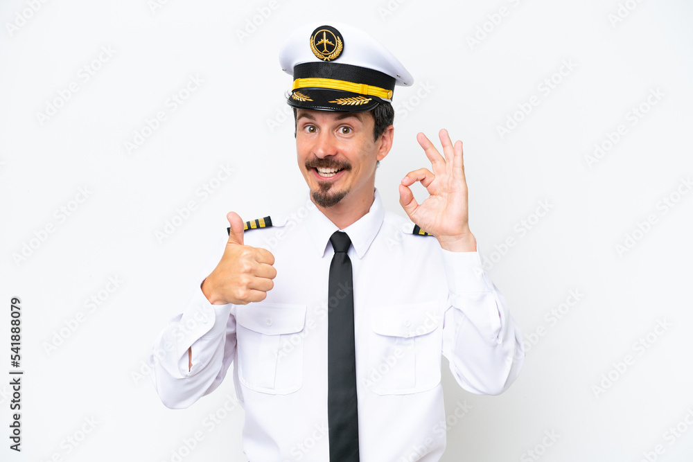 Airplane caucasian pilot isolated on white background showing ok sign and thumb up gesture