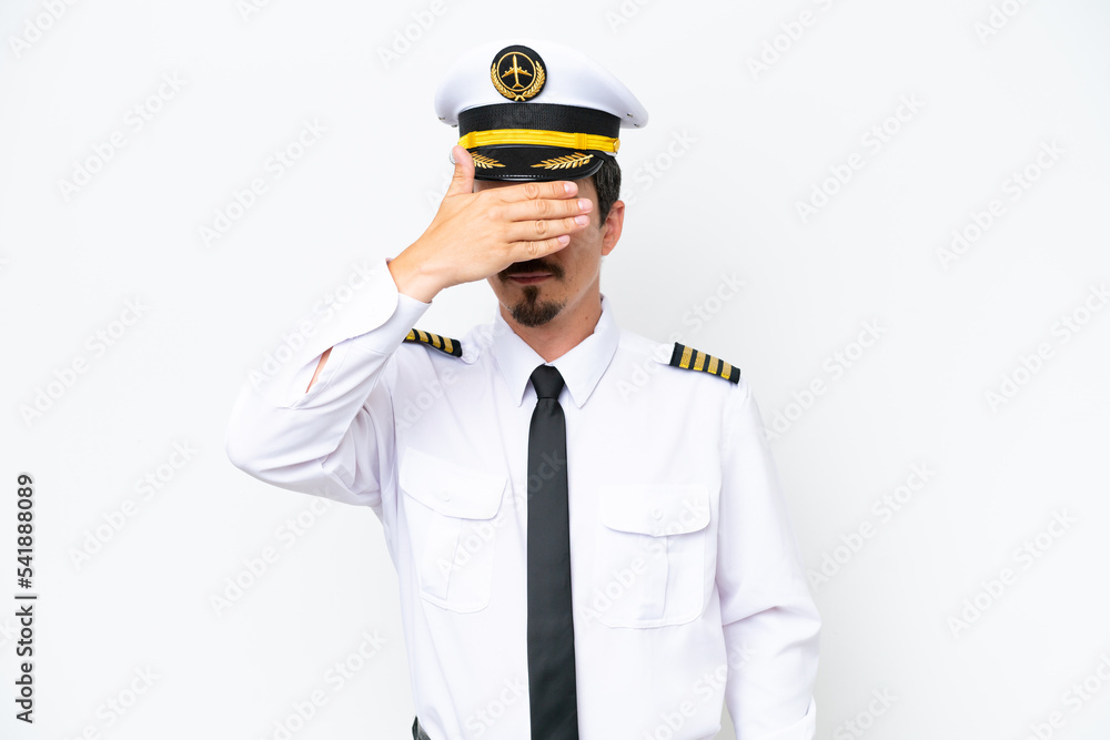 Airplane caucasian pilot isolated on white background covering eyes by hands. Do not want to see something