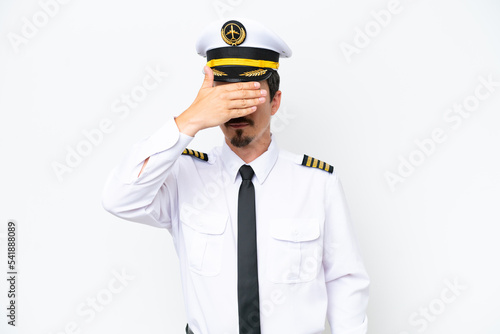 Airplane caucasian pilot isolated on white background covering eyes by hands. Do not want to see something