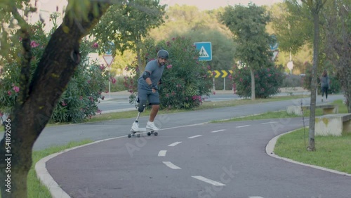 Wallpaper Mural Mid adult man with prosthetic leg skating on board in park. Skateboarder with disability riding longboard along track. Disability concept Torontodigital.ca