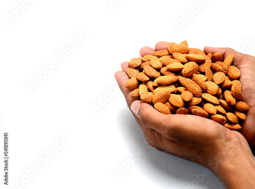 Fresh almonds in the wooden bowl, Organic almonds, almonds border white background, Almond nuts on a dark wooden background. Healthy snacks. Top view. Free space for text. photo