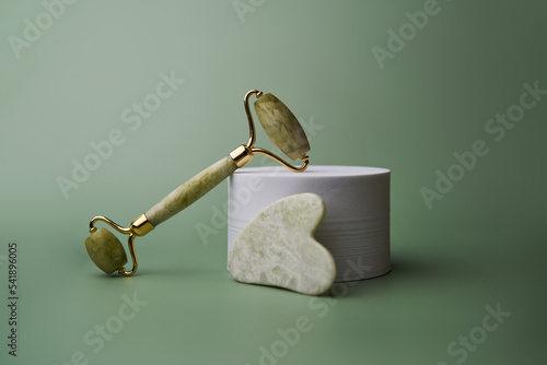 Green jade face roller and Gua Sha scraping for beauty facial massage therapy