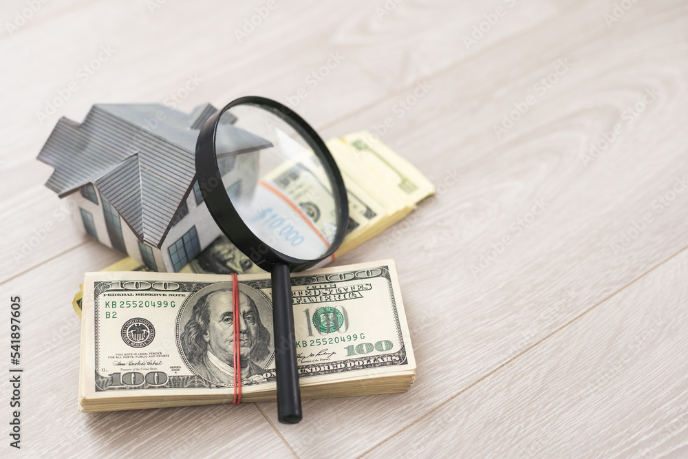 Model of house with magnifying glass and money on white. Model of house with magnifying glass and money on white.