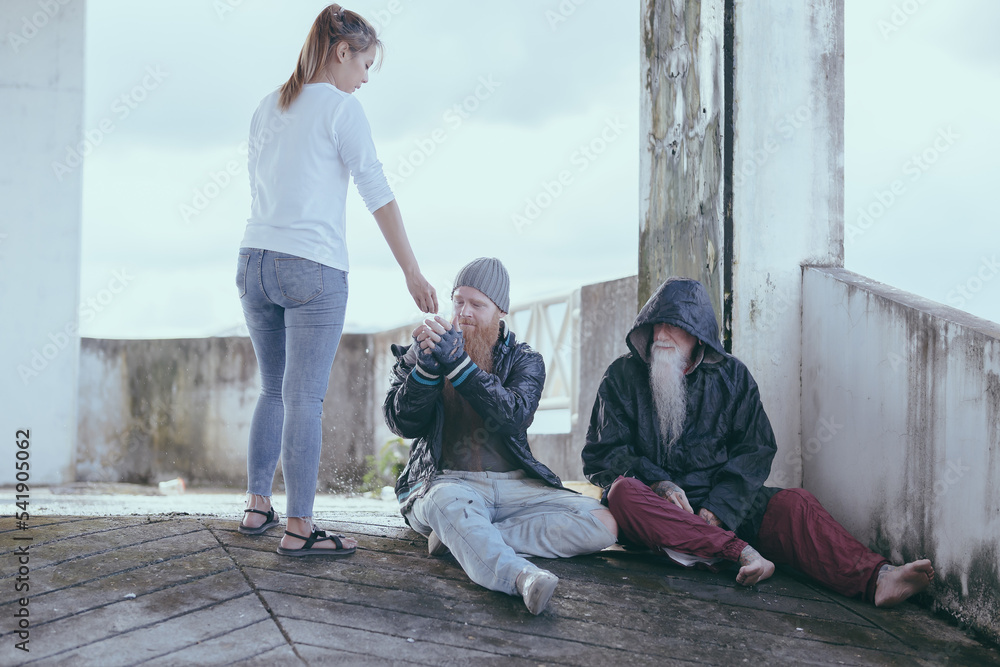  female giving money to poor or homeless people poverty beggar in the city sitting on the streets with a sign for help., homeless poor people and depression concepts.