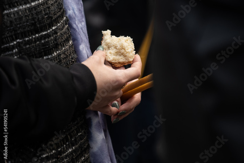 Adult and faithful in Jesus Christ woman in a holy communion pray and holding loaf bread and candles. Holy communion in church. The Feast of Corpus Christi Concept.