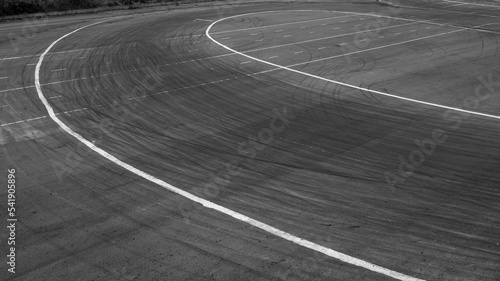 Background with tire marks on road track  Car track asphalt pavement background at the circuit  Abstract asphalt road background with crossing of tires tracks  Black tyre mark on asphalt road.