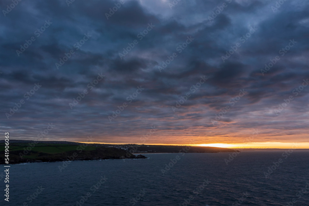 Beautiful aerial drone landscape image of Prussia Cove at sunrise in Cornwall England with atmospheric daramatic sky and clouds