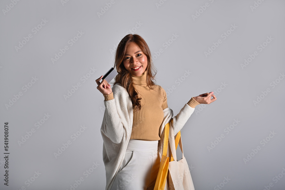 Naklejka premium Millennials Asian woman enjoy with credit card and hold shopping bag over the with background.