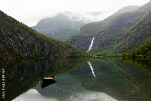 Rowboat on a lake with waterfall reflection, Norway