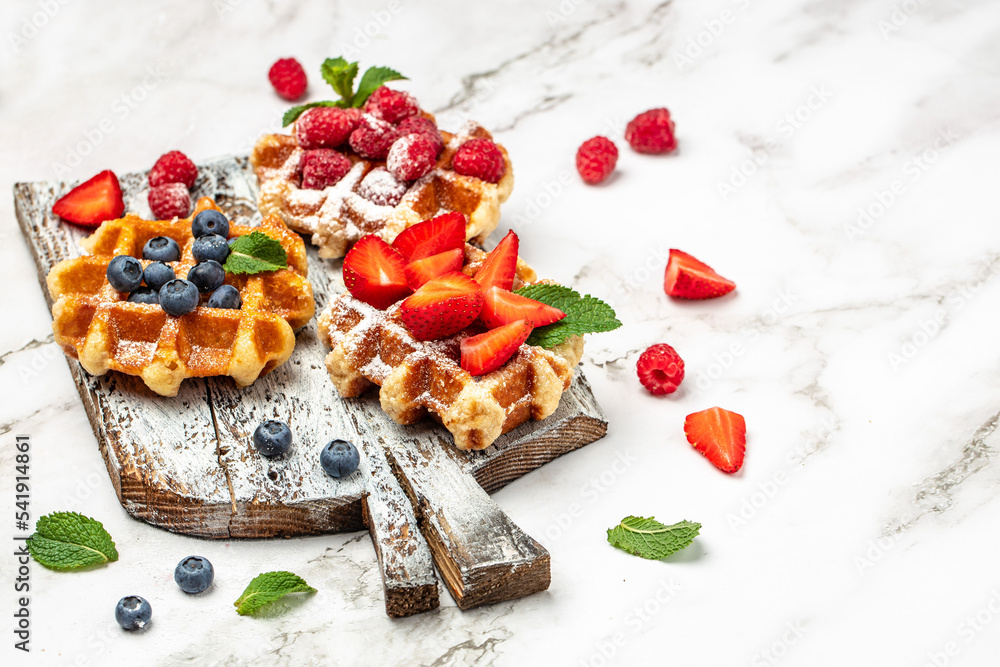 belgian waffles with fresh fruit on a light background. Long banner format. top view