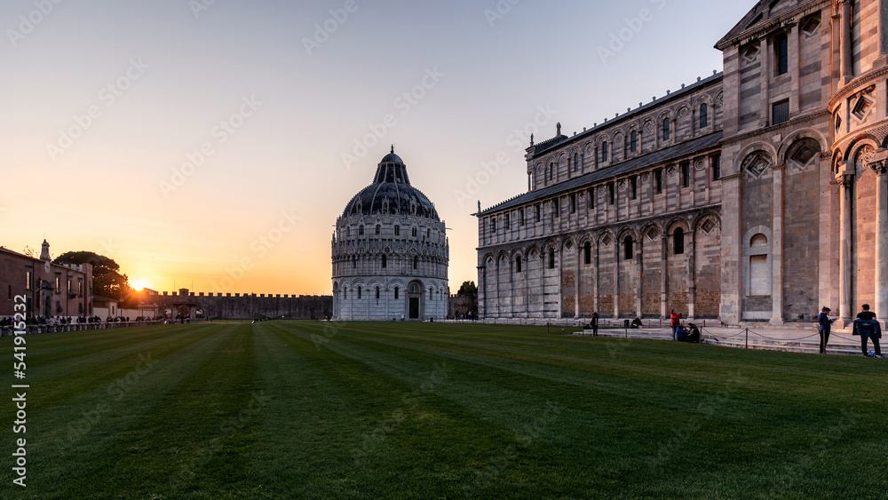 Large park, the Baptistery and the Cathedral of Pisa at sunset. Italy