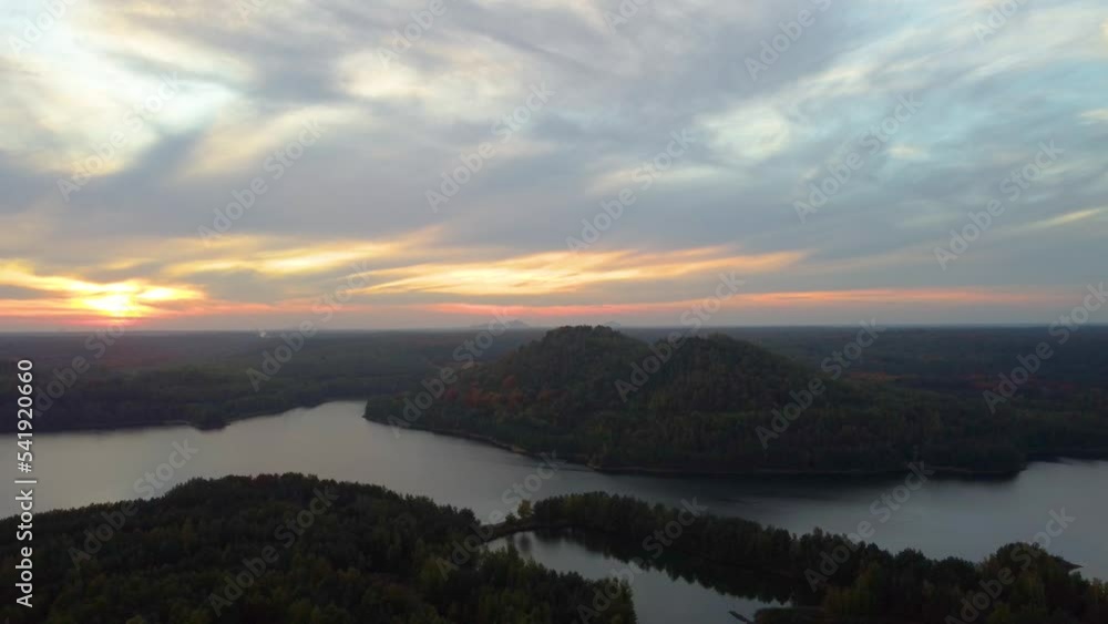 Mountain covered in autumn forest near beautiful lake with flying birds Mountain covered in autumn forest near beautiful lake with flying birds