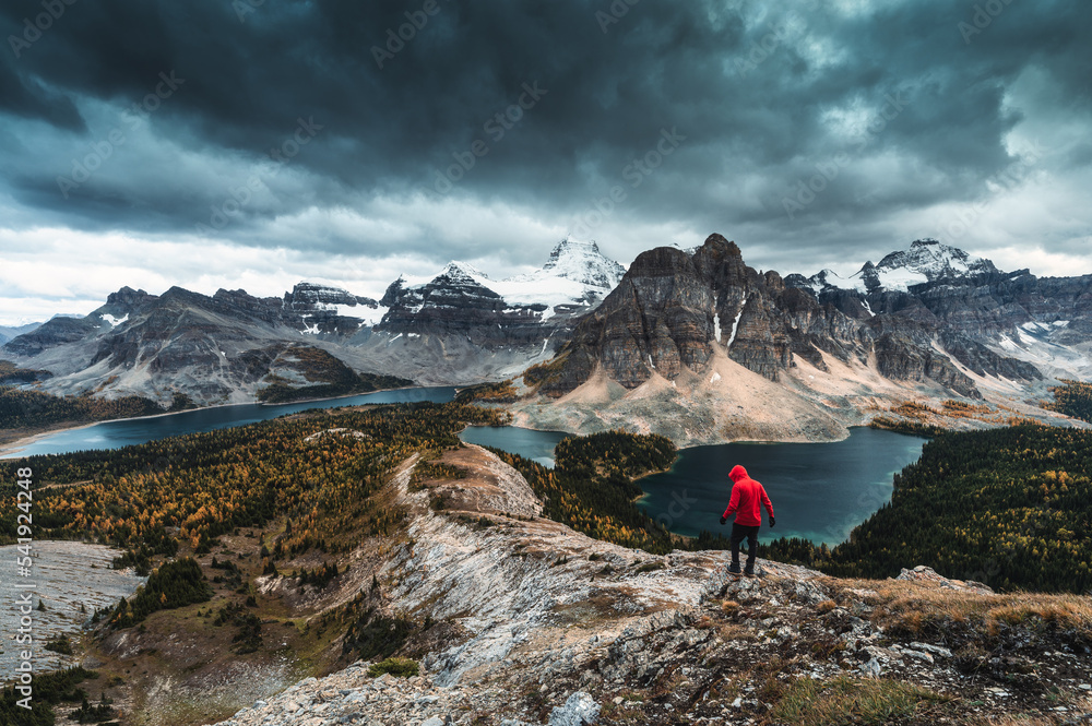Moody of Nublet peak with mount Assiniboine and hiker standing in autumn at national park