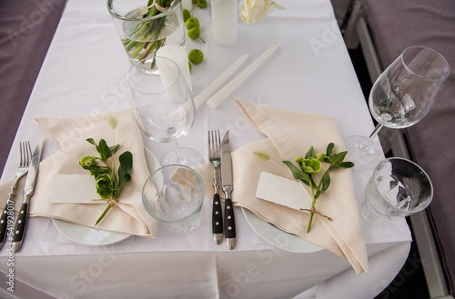 Obraz na płótnie Serving the table for the holiday. Festive floral decor on the plates. Place for the inscription of the guest’s name. Beautiful decor for the festive event w salonie