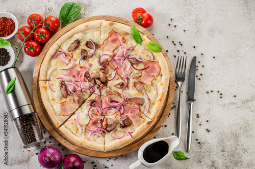 Tasty pizza with ham, mushrooms and onion on the concrete background