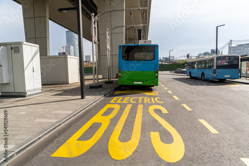 Electric bus at a stop is charged by pantograph