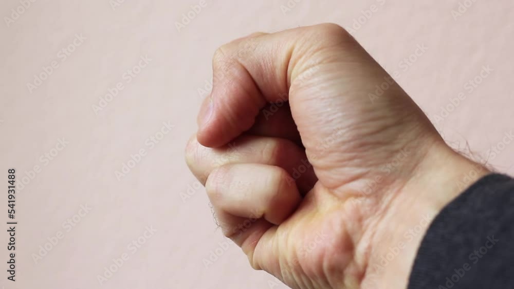 Male hand clenching a bullet into a fist close-up Male hand clenching a bullet into a fist close-up