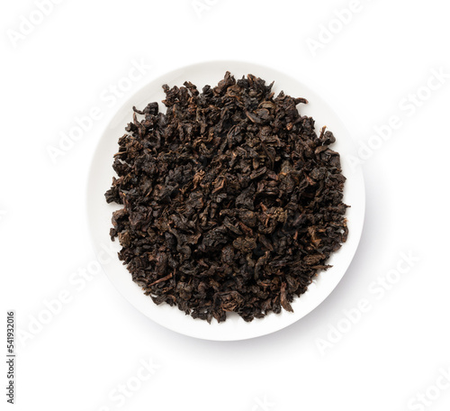 Tea leaves. A pile of dried oolong tea leaves in a white porcelain plate.