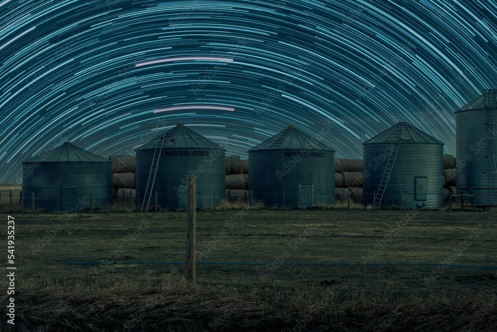 Grain sheds and hay bales in a field Shouldice Alberta Canada Grain sheds and hay bales in a field Shouldice Alberta Canada