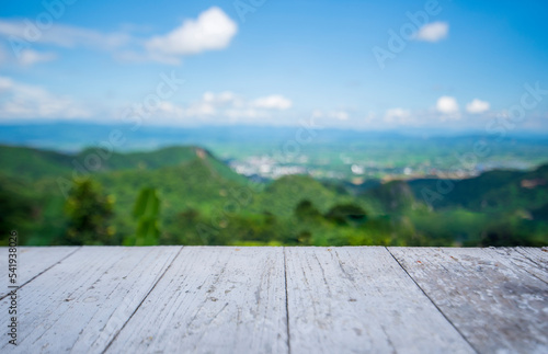 wooden table and beauty blur sky and mountains as background.