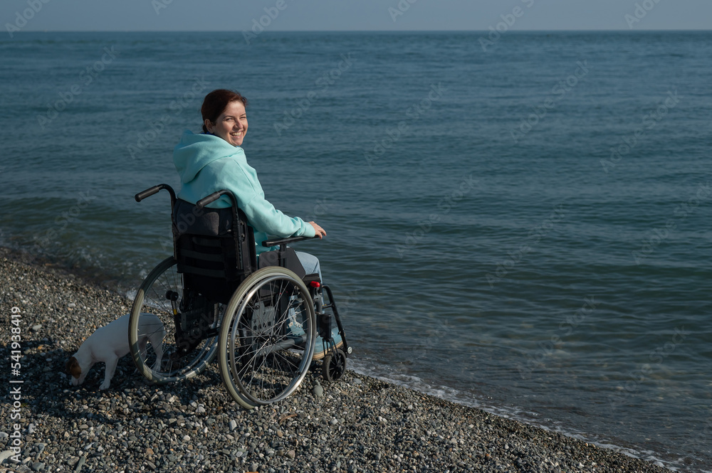 Pacified caucasian woman in a wheelchair on the seashore. 