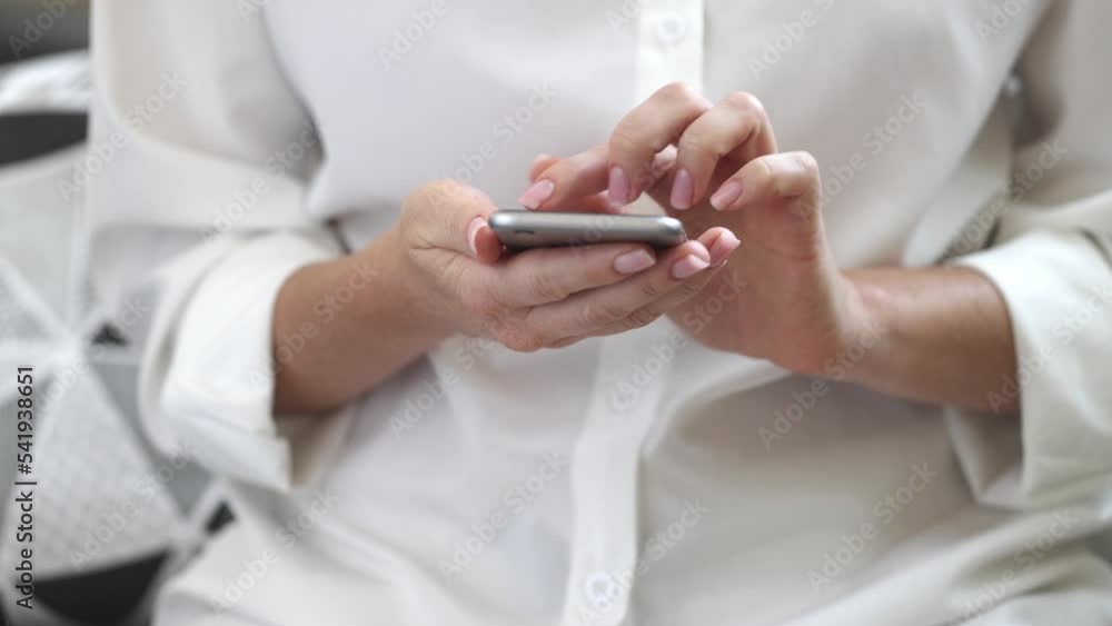 Woman typing message on a smartphone. Closeup of female hands texting. Woman typing message on a smartphone. Closeup of female hands texting.
