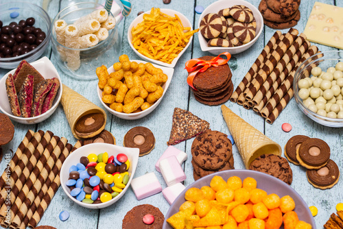 Salty and sweet snacks. Table of salty and sweet snacks. Large group of unhealthy food