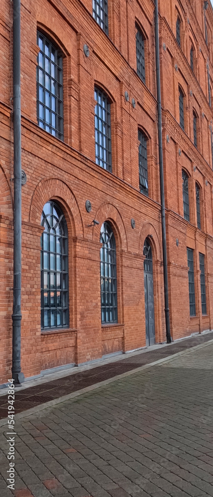 The facade of a revitalized post-industrial building. Windows in a renovated brick building.