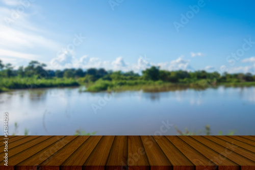 Wooden table background with a river view to place your products with various creative ideas.
