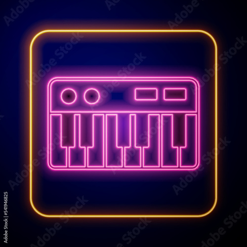 Glowing neon Music synthesizer icon isolated on black background. Electronic piano. Vector